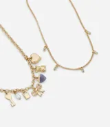 Collar de dos capas en metal con baño dorado. La primera capa presenta una cadena mediana con dijes variados que incluyen un corazón, un osito, un corazón de resina, un lazo, un candado, una llave y una perla. La segunda capa consiste en una cadena más fina con pequeños dijes ovalados de cristal distribuidos a lo largo.
