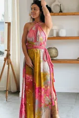 Vestido largo de seda con estampado abstracto en tonos marrones, beige y destellos dorados, con escote en V profundo, tirantes de cuerda anudados al cuello y la cintura, y tajo lateral en la falda.