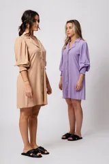 Vestido corto color tostado, con cuello solapa, abotonado al frente y mangas 3/4 con puños fruncidos.