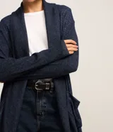 Cardigan alargado de punto color gris, sin cierre frontal y con mangas largas.