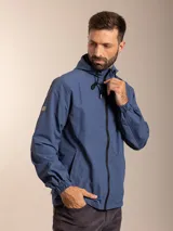 Campera de nylon con capucha, cierre frontal y forro de red. Presenta un diseño minimalista en color beige con detalles en negro.