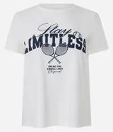 Remera de algodón color blanco con estampa frontal en azul marino que dice "Stay LIMITLESS" y un dibujo de dos raquetas de tenis cruzadas con una pelota.