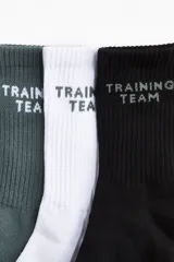 Pack de cinco pares de medias deportivas de caña media con tejido funcional absorbente. Presentan diseño acanalado en la caña, borde superior elástico y talón y punta reforzados. Incluyen el texto 'TRAINING TEAM' bordado en la parte superior.