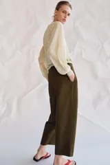 Pantalón cropped de tiro medio con diseño de pinzas en el delantero, trabillas para cinturón, bolsillos laterales y bolsillos de vivo en la parte trasera. Cierre frontal con cremallera y botón.