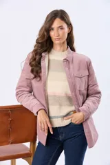 Campera de pana color rosado con interior de corderito sintético. Cuenta con cierre frontal de botones metálicos, cuello camisero, bolsillos con solapa en el pecho y mangas largas.