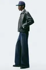 Jean de cinco bolsillos en denim de algodón rígido, color azul oscuro. Modelo de corte holgado de cadera a bajo con pierna amplia y tiro caído. Cintura estándar y cierre.