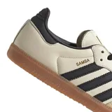 Championes Adidas Samba Og color beige con detalles en negro y suela de goma marrón.