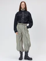 Pantalón sastrero de tiro medio y pierna ancha, con diseño a rayas verticales finas y detalle de vivos negros en la pretina y a lo largo del frente.