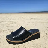 Zuecos de cuero color tostado con textura de reptil, plataforma baja y suela cómoda.