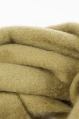 Bufanda larga color beige con flecos en los extremos.