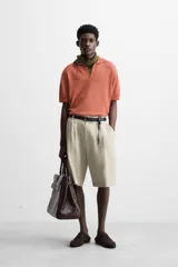 Polo de punto de corte relajado, confeccionado en mezcla de algodón. Presenta cuello solapa con abertura frontal, manga corta y acabados en rib en puños y bajo.