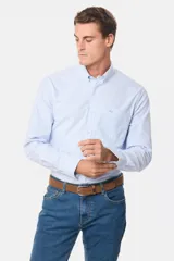 Camisa de vestir celeste con rayas verticales blancas, de corte clásico, con cuello abotonado y bolsillo en el pecho.