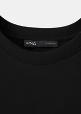 Remera negra de algodón, con diseño recto, cuello redondo y manga corta.