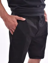 Bermuda de gabardina negra con bolsillos laterales y traseros. Diseño clásico con ruedo doblado.