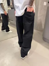 Jean estilo barrel de corte oversize en color negro, con diseño estructurado de silueta curva y tiro alto.