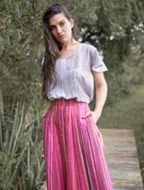 Falda larga de lino con estampado a rayas verticales en tonos rosados, fucsias y marrones.