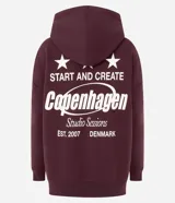 Buzo tipo hoodie color bordó, con corte oversized, capucha ajustable con cordones y bolsillo canguro delantero. Presenta un estampado gráfico pequeño en el pecho con tipografía estilo college.