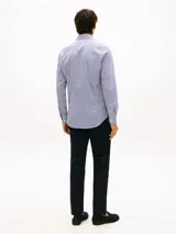 Camisa de manga larga de Tommy Hilfiger, con diseño de rayas verticales azules y blancas, cuello rígido y cierre frontal con botones.