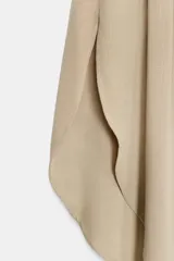 Falda midi de tiro medio color beige, con cintura elástica en la espalda y diseño asimétrico con aberturas laterales.