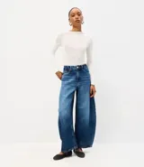 Pantalón barrel en jean de tiro alto con calce amplio y botamanga levemente afinada, de color azul, con recortes laterales, pespuntes contrastantes y bolsillos funcionales.