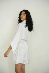 Bata color crema confeccionada en seda, con lazo de ajuste en la cintura.