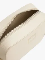 Bandolera Tommy Jeans color crema con logo tonal en el frente, correa ajustable y cierre de cremallera.