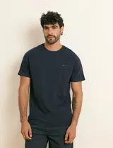 Remera básica de algodón color beige, de manga corta, con cuello redondo y un pequeño detalle bordado en el pecho.