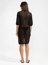 Camisa larga negra de punto calado con cuello camisero, manga tres cuartos y cierre frontal con botones.