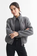 Campera gris de corderito con cierre frontal y cuello alto.