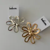 Par de aros con forma de flor, uno plateado y otro dorado.