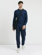 Pantalón jogging de tejido circular con cintura elástica y cordón ajustable. Presenta puños elastizados en el ruedo y bolsillos laterales.