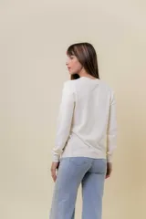 Buzo de punto color beige melange, de manga larga, cuello redondo y corte recto.
