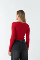 Top de tejido de punto acanalado color rojo, con escote en V, manga larga y detalle de jareta frontal ajustable con cordón.