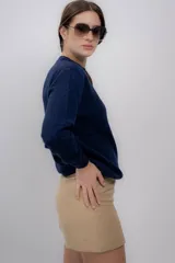 Sweater gris de tejido de punto, con cuello redondo y mangas largas.