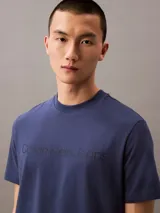 Remera azul de algodón con cuello redondo, mangas cortas y logo "Calvin Klein Jeans" estampado en el pecho.