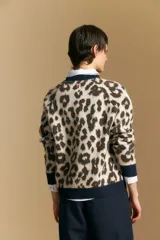 Sweater de tejido jacquard con estampado animal print, de silueta relajada y manga larga. Presenta cuello redondo y bordes en contraste de color bordó.