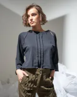 Pantalón verde militar tornasolado de algodón brillante, corte a la cintura y piernas rectas con textura de tableado central.