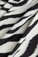 Top de punto de ajuste entallado con estampado de cebra. Modelo de manga larga con pliegues laterales que crean un efecto drapeado.