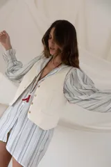 Chaleco color chocolate con botones dorados y bolsillos frontales.