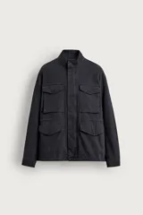 Cazadora regular fit de color negro con efecto lavado, confeccionada en tejido de algodón. Cuenta con cuello subido, manga larga con puño abotonado y múltiples bolsillos frontales de plastrón con solapa. Presenta cintura ajustable con cordón interior y cierre frontal con cremallera oculta por solapa con botones a presión.