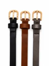 Pack de tres cinturones finos de cuero sintético con hebilla metálica dorada. Incluye un cinto negro, uno marrón y uno gris.