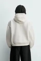 Sudadera tipo hoodie de corte boxy fit, confeccionada en tejido doble compacto de mezcla de algodón. Presenta cuello con capucha, manga larga y acabados en el mismo tejido.