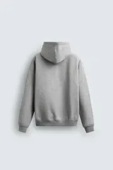 Sudadera tipo hoodie de corte relajado, confeccionada en tejido de algodón con interior cepillado. Presenta capucha con cordones ajustables, bolsillo frontal tipo canguro y terminaciones en rib en puños y ruedo.