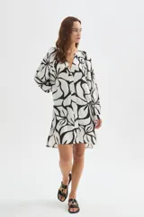 Camisa tipo vestido de viscosa con estampado floral abstracto en blanco y negro, cuello en V con botonera frontal completa, mangas largas abullonadas y diseño holgado.