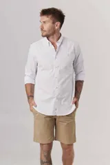 Camisa de hombre color crema, de corte clásico, con cuello abotonado y mangas largas.