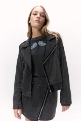 Campera negra de corte rockero con tachas plateadas, cierre asimétrico y cuello solapa.