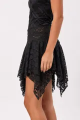 Falda corta asimétrica color negro, confeccionada en tela liviana con diseño en capas y bordes de encaje.