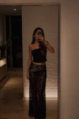Pollera larga de encaje negro con diseño semitransparente y cintura elástica.