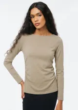Blusa de manga larga color beige oscuro, con escote bote y diseño ajustado con fruncidos sutiles en los laterales.