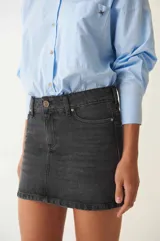 Minifalda de denim negro con tiro bajo, corte recto y bolsillos funcionales.